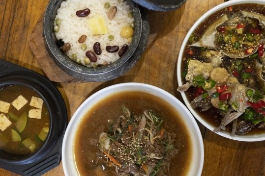 위에서 본 한 상 — 콩을 얹은 돌솥밥, 된장찌개, 국물 불고기, 간장게장